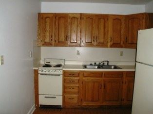 Louisville apartment for rent - A kitchen with wooden cabinets and a white stove.