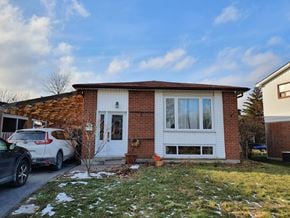 Toronto house for rent - A house with a white door and windows is surrounded by a grassy area with snow on the ground.