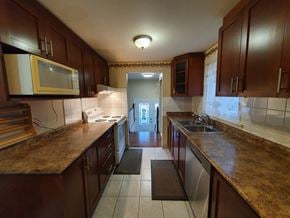 Toronto house for rent - A kitchen with brown cabinets and a yellow microwave.