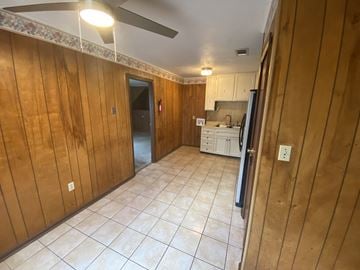 Hattiesburg house for rent - a kitchen with a tile floor and wooden walls