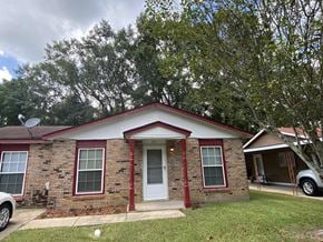 Hattiesburg house for rent - a small brick house with a yard and a tree