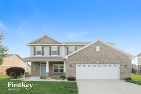 New Palestine house for rent - A house with a garage and a driveway in front of it.