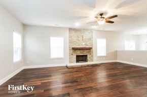 New Palestine house for rent - A spacious room with a fireplace and wooden floors.