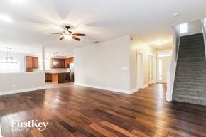 New Palestine house for rent - A spacious room with wooden floors and a ceiling fan.