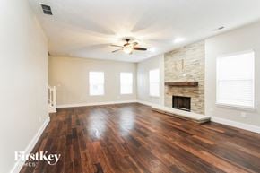 New Palestine house for rent - A room with wooden floors and a stone fireplace.