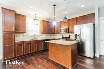 New Palestine house for rent - A kitchen with wooden cabinets and a granite countertop.
