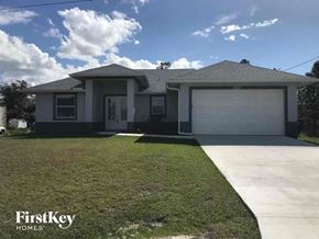 Lehigh Acres house for rent - A house with a garage and a driveway is for sale.