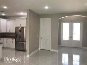 Lehigh Acres house for rent - A kitchen with a refrigerator, cabinets, and a countertop.