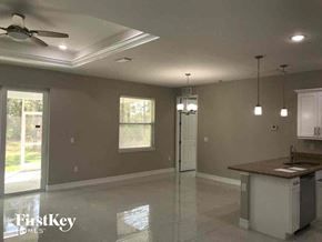 Lehigh Acres house for rent - A spacious kitchen and living room with a ceiling fan and pendant lights.