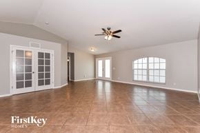 Cape Coral house for rent - an empty living room with a ceiling fan and a large window