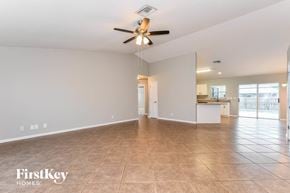 Cape Coral house for rent - a spacious living room with a ceiling fan and tile flooring