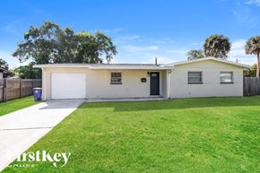 Rockledge house for rent - A white house with a black door and a white garage door.