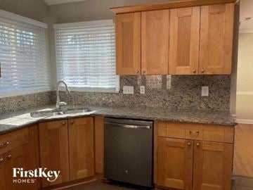 Matthews house for rent - a kitchen with wooden cabinets and a stainless steel dishwasher