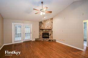 Jacksonville house for rent - a living room with a stone fireplace and a ceiling fan