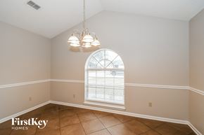 Jacksonville house for rent - a dining room with a large arched window and tiled floors