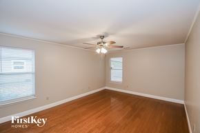 Jacksonville house for rent - a bedroom with wood flooring and a ceiling fan