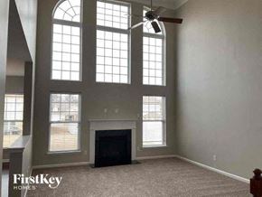 Concord house for rent - a large living room with a fireplace and large windows