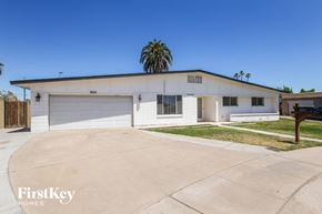 Phoenix house for rent - A two-story house with a garage and a palm tree in the backyard.