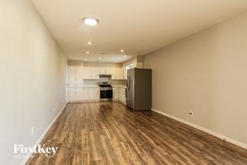 Phoenix house for rent - A spacious room with wooden flooring and a kitchenette in the background.