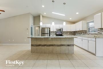 North Port house for rent - a large kitchen with white cabinets and a counter top