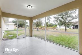 North Port house for rent - a living room with large windows and a view of the yard
