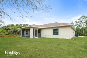 North Port house for rent - a small house with a grassy yard and a backyard
