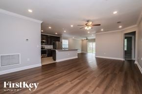 Spring Hill house for rent - A spacious room with wooden floors and a ceiling fan.