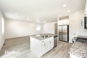 Mead house for rent - a white kitchen with granite counter tops and a stainless steel refrigerator