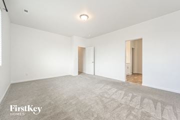 Mead house for rent - a living room with white walls and carpet and a door to a hallway