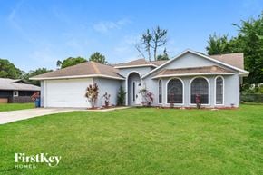 Palm Bay house for rent - a white house with a lawn and a garage