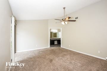 Palm Bay house for rent - a spacious living room with carpet and a ceiling fan