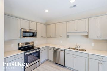 Parrish house for rent - A kitchen with white cabinets and stainless steel appliances.