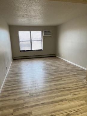 Wahpeton apartment for rent - A room with wooden flooring and a window with blinds.