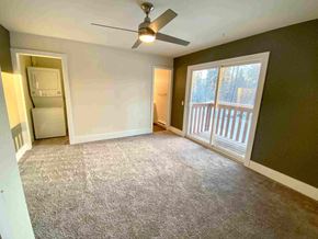 Anchorage apartment for rent - an empty living room with a ceiling fan and a window