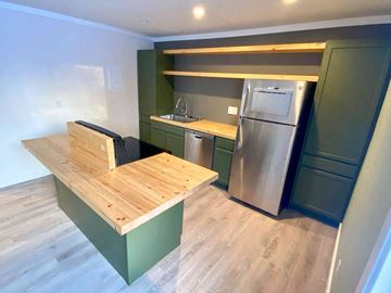 Anchorage apartment for rent - a kitchen with a wooden table and a stainless steel refrigerator