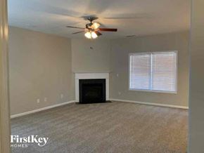 Indian Trail house for rent - an empty living room with a ceiling fan and a fireplace