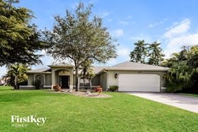 Cape Coral house for rent - a house with a lawn and a garage
