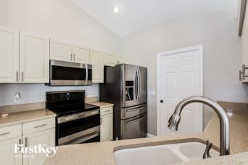 Cape Coral house for rent - a kitchen with stainless steel appliances and a sink