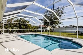 Cape Coral house for rent - a pool is under a white roof next to a pool