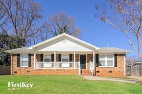 Charlotte house for rent - a small brick house with a porch and a lawn