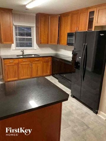Charlotte house for rent - a kitchen with black appliances and wooden cabinets