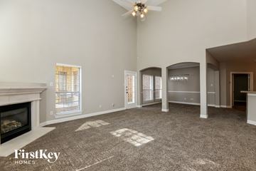 Grand Prairie house for rent - A spacious living room with a fireplace and a carpet on the floor.