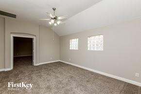 Grand Prairie house for rent - A spacious room with a ceiling fan and carpeted floor.