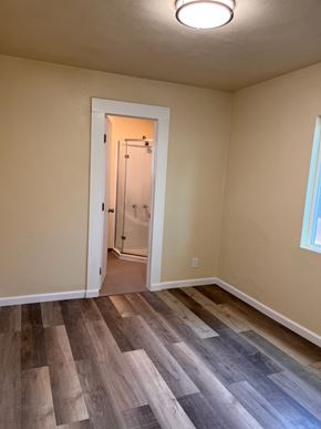 Ontario apartment for rent - an empty room with wooden floors and a door to a bathroom