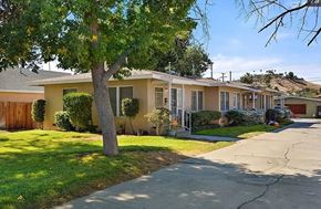 San Bernardino apartment for rent - a yellow house with a tree and a sidewalk