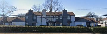 Dallas apartment for rent - A large house with a grey roof and a white fence.