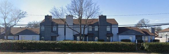 Dallas apartment for rent - A large house with a grey roof and a white fence.