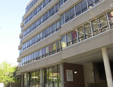 Cambridge apartment for rent - A tall building with a sign that says "Trio" on the front.