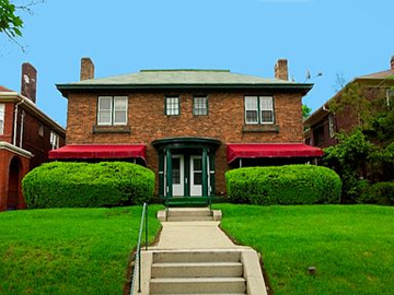 Pittsburgh apartment for rent - A red brick house with a green door and a red awning.