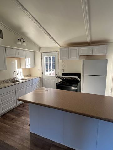 Rothschild apartment for rent - A kitchen with a white fridge and a wooden counter.